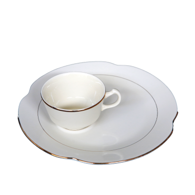 A snack plate with decorative gold rings on and near the edge. A matching cup sits on it.