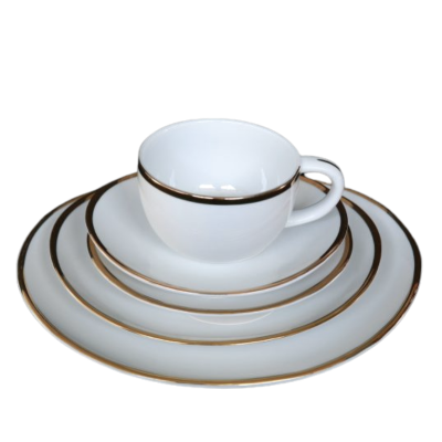 A stack of differently sized oval plates with gold rims. On top is a gold rimmed coffee mug.