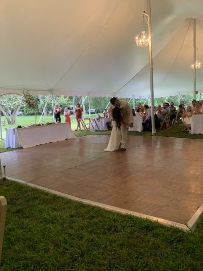 A photo of a parquet dance floor, with wooden tiles laid in opposing patterns. A bride and groom are dancing on it.