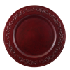 A red acrylic charger with decorative flourishes around the rim.