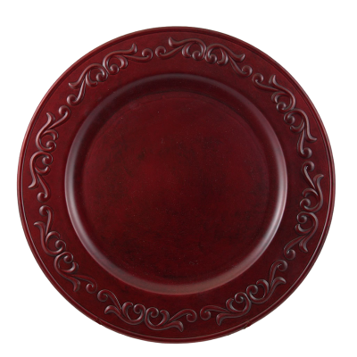 A red acrylic charger with decorative flourishes around the rim.