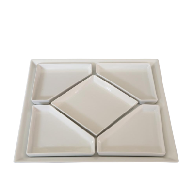 A ceramic tray with a diamond dish inserted in the center and four triangle inserts in the corners.