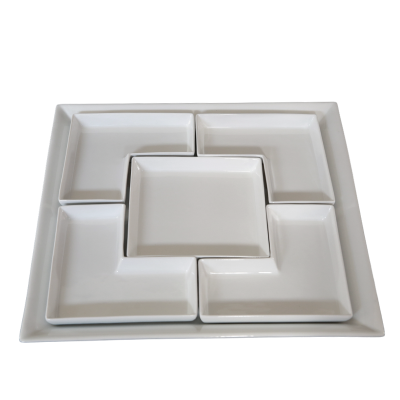 A ceramic tray with a square dish inserted in the center and four corner inserts.