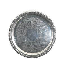 A round serving tray with embossed details.