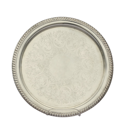 A round serving tray with an embossed design.