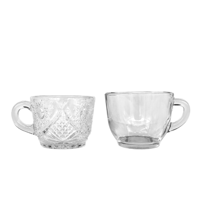 Two punch cups, one plain glass and the other with an etched, ornate pattern.