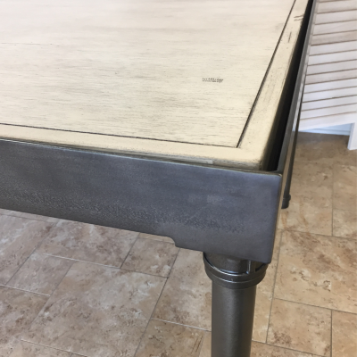 A detail shot of an Edison style farm table with a white washed surface.