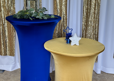 pedestal tables at a 40" bar top height and a 36" medium height with blue and gold spandex linens in high school graduation colors
